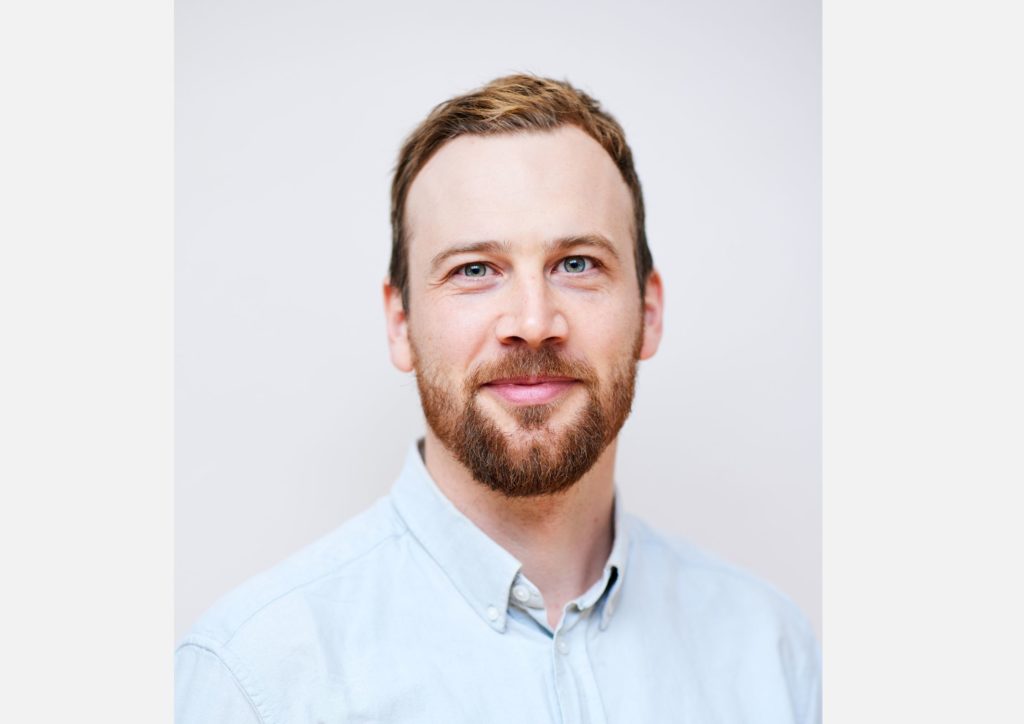 Christian Drabløs, forretningsutvikler i Spleis. Han har på seg lyseblå skjorte og står foran en lys bakgrunn. 