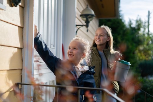 Illustrasjonsfoto av to jenter som er bøssebærere for TV-aksjonen og ringer på dører for å samle inn penger. 